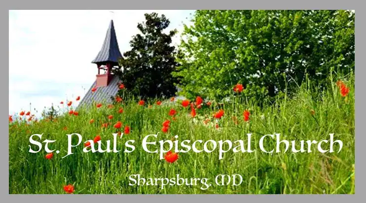 St. Paul's Episcopal Church, Sharpsburg, MD, visible behind a grassy field with red flowers, under a clear sky with nearby trees.